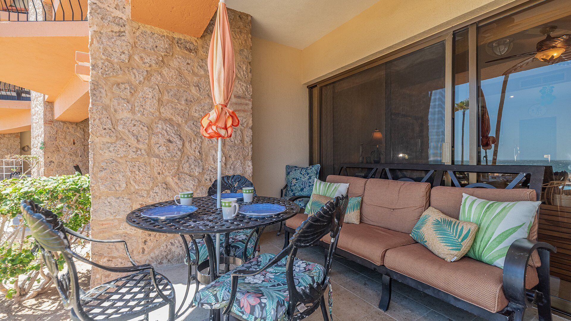 An outdoor patio area with a round table, chairs, and a sofa.