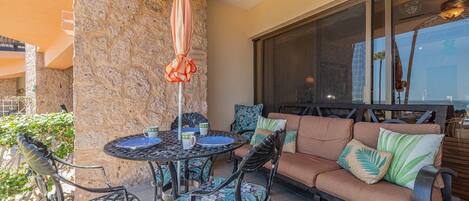 An outdoor patio area with a round table, chairs, and a sofa.