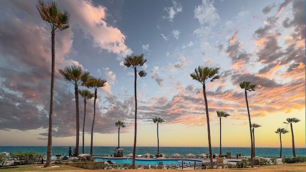 A resort with a pool, palm trees, and a sunset view. - Sonoran Sea W-109 Serenity By The Sea Bright Oceanfront Condo (Puerto Peñasco)