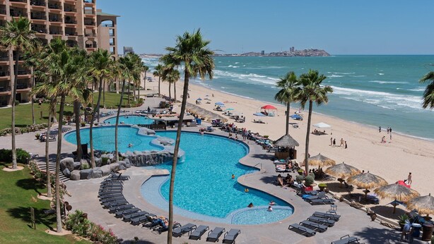 Un complexe hôtelier doté d’une grande piscine, d’une plage et offrant une vue sur l’océan.