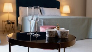 A bedroom with a bed, two bedside lamps, a round table with two glasses and two mugs, and a small decorative item on the table. - Elegant apartment, in the heart of the historic center of Noto, for 2 to 6 guests (Noto)