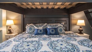A bedroom with a dark headboard, patterned bedding, and two bedside lamps. - Sonoran Sea East 711 Beautiful Spacious Ocean View Condo (Puerto Peñasco)
