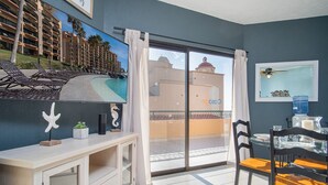 A room with a balcony, a dining area, and a view of a building with a dome. - Sonoran Sea East 711 Beautiful Spacious Ocean View Condo (Puerto Peñasco)