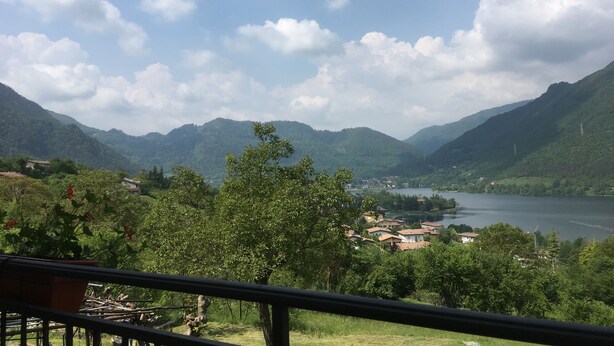 Une vue pittoresque d’un lac entouré de montagnes, avec un petit village au premier plan.