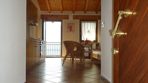 Un escalier menant à une salle à manger dotée d’un plafond en bois et d’un sol carrelé.