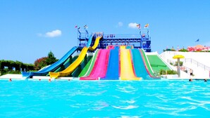 Un parque acuático con varias toboganes de colores y una piscina.