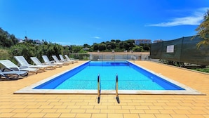 A rectangular swimming pool with two ladders, surrounded by sun loungers and a tiled deck. - 6a Fabrica velha Beautiful house + pool walking distance to beach (Carvoeiro)