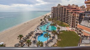 Un resort con una piscina grande, playa y vista al océano.