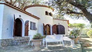 Un edificio con pareti bianche, diverse porte in legno e una scala in pietra che conduce all'ingresso.