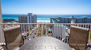 A balcony with wicker chairs overlooking a beach and cityscape. - Ariel Dunes I 1908-Beach Access and 3 Pools! (Miramar Beach)