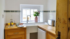 A kitchen with a sink, a coffee maker, a toaster, and a window with a plant. - 2 bedroom accommodation in Greenwell, near Brampton (Greenwell, near Brampton)