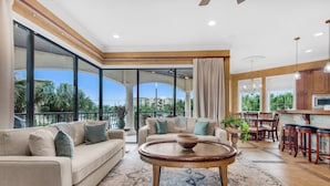 A spacious living area with a large window, a round coffee table, and a sofa. - 🏖️ Beach Service Included! | 750 ft to Beach | 4 BR | Villa Tuscana (Miramar Beach)