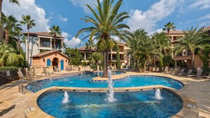 A pool area with a central fountain, surrounded by palm trees and lounge chairs. - 🏖️ Beach Service Included! | 750 ft to Beach | 4 BR | Villa Tuscana (Miramar Beach)