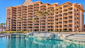 A multi-story hotel with a pool area in front. - Sonoran Sea West 407 Ocean View Condo (Puerto Peñasco)