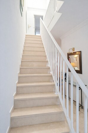 A staircase with white railings and beige steps leading to an upper floor. - V2 Jardim da Oura, piscina, BBq, praia a 500m. (Albufeira)