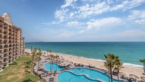 Un complexe hôtelier comprenant un grand bâtiment, une piscine et une plage.