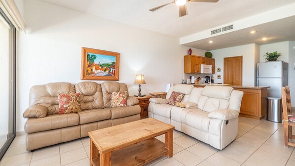 A living room with two sofas, a wooden coffee table, and a painting on the wall.