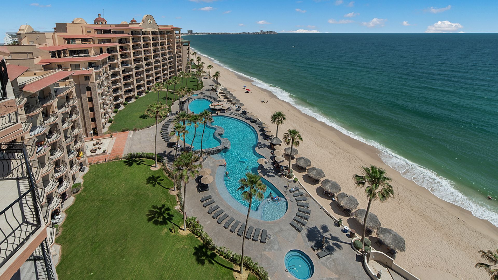 Ein Resort mit großem Pool, Strand und Meerblick.