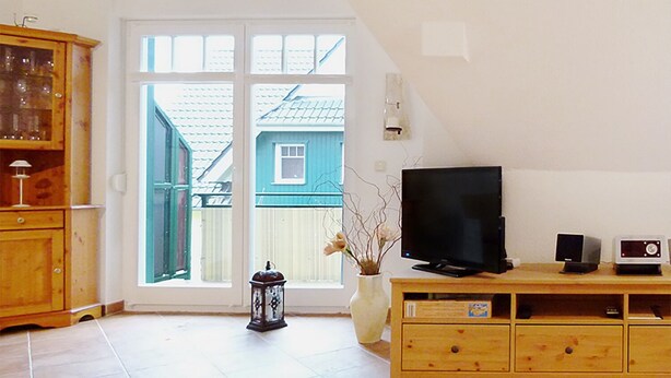 A living room with a TV, speakers, and a wooden cabinet. - cozy apartment near the Darßwald, beach chair on balcony, WiFi, 4 pers. (Prerow)