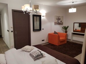Relax in a stylish space with a large bed, sofa, and potted plant.
