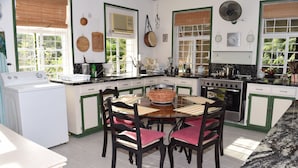 A kitchen with a dining table, chairs, and a stove. - Eco-friendly room in the Hummingbird apartment (St. Michael)