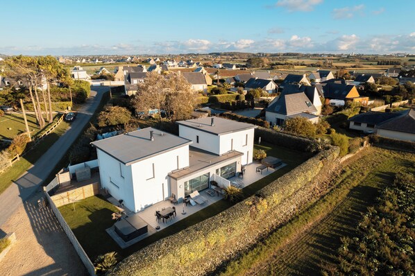 A modern two-story house with a patio, surrounded by a rural landscape. - Villa Enora Bord de Mer : Pool 29°C, Private Spa & Beach and path 100m away (Sibiril)