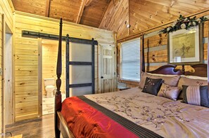 Una camera da letto con rivestimenti in legno, un letto a baldacchino, una porta scorrevole e un quadro incorniciato sopra il letto.