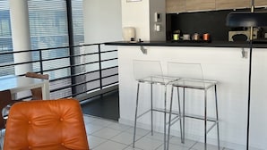A modern kitchen with a black countertop, white cabinets, and a black floor lamp. - PARIS 12ème - 110 m² apartment near ARENA BERCY and Place DAUMESNIL (Paris)