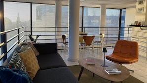A modern office space with a sofa, chairs, a table, and large windows. - PARIS 12ème - 110 m² apartment near ARENA BERCY and Place DAUMESNIL (Paris)