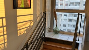 A staircase with wooden steps and black railings, leading to a landing with a view of a building through a window. - PARIS 12ème - 110 m² apartment near ARENA BERCY and Place DAUMESNIL (Paris)