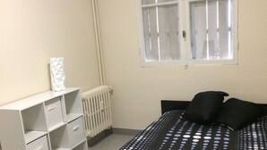 A bedroom with a bed, a radiator, a window, and a white storage unit. - Charming two room city center (Nice)