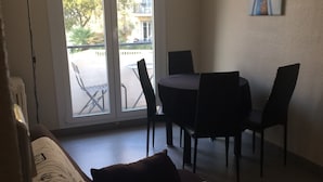 A room with a bed, a table, and chairs. There is a window with a view of the outside. - Charming two room city center (Nice)