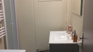 A compact bathroom with a washing machine, a sink, and a mirror. - Charming two room city center (Nice)