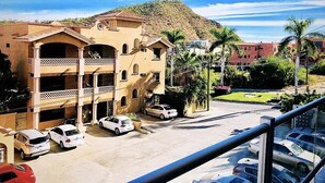 Um edifício de vários andares com uma área de estacionamento na frente.