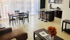 Uma sala de estar moderna com área de jantar, cozinha e varanda com vista.