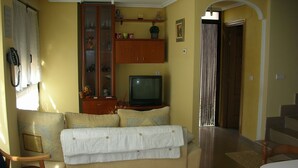 A living room with a sofa, a television, a cabinet, and a staircase leading to another room. - The Petra y Armando house in Anguiano (Anguiano)