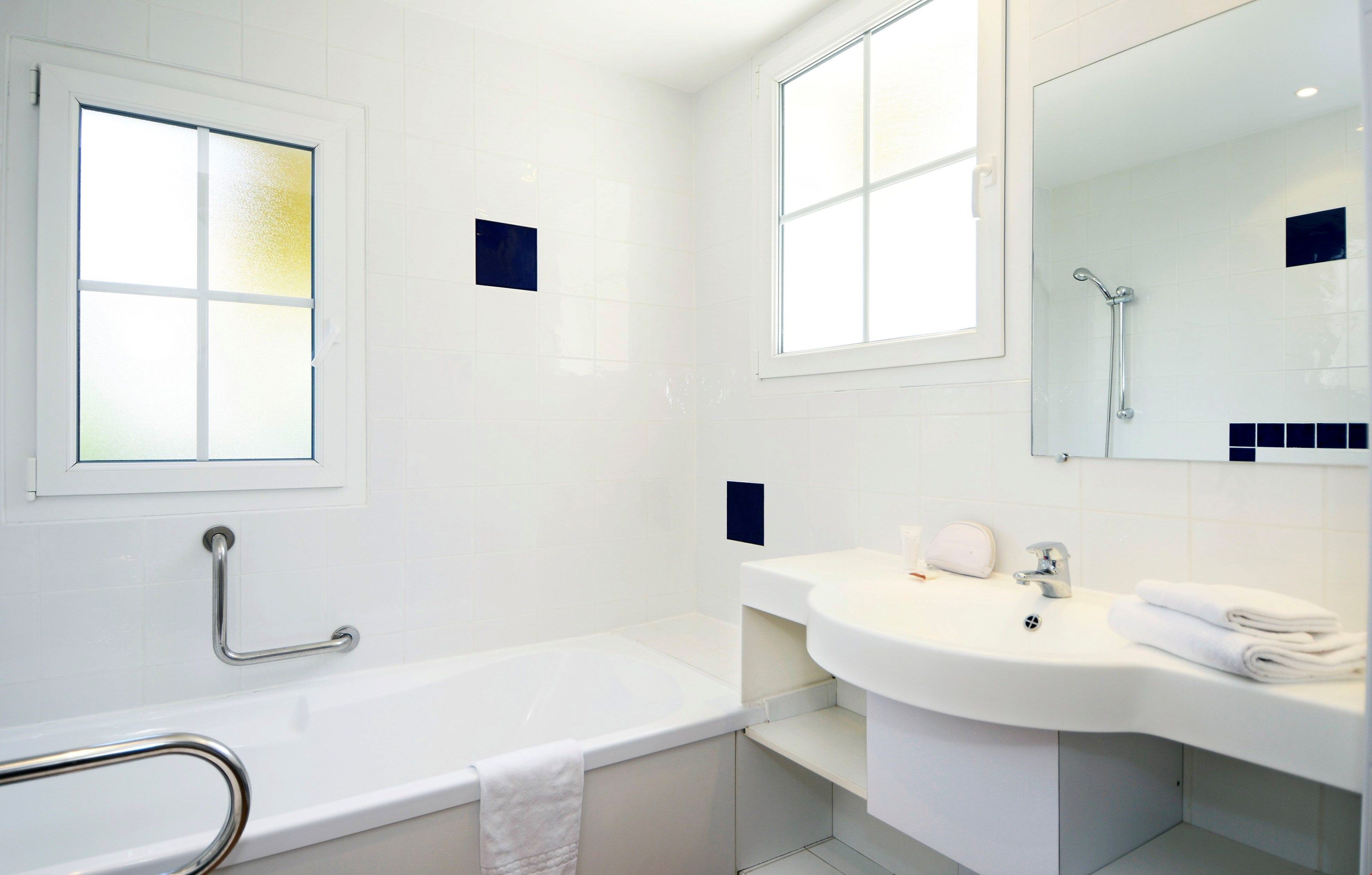 A modern bathroom with a bathtub, a sink, and a mirror.