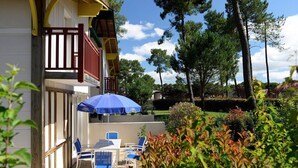 A hotel patio with outdoor seating and a blue umbrella.
