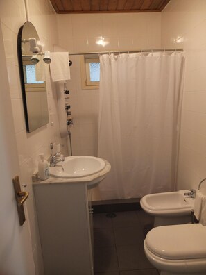 Kombination af bruser/badekar, hårtørrer, bidet, håndklæder