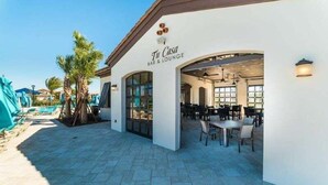 A bar and lounge area with outdoor seating and a poolside view. - 5BR Windsor Townhome | Private Splash Pool | Sleeps 12 | Dog Friendly | Near Disney (kissimmee)