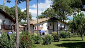 A two-story building with balconies, surrounded by trees and greenery. - Wi-Fi Gratuit! Appart équipé, au cœur du Golf (Gujan-Mestras)