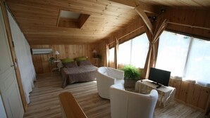 Eine Holzhütte mit Schlafzimmer auf Schlafgalerie, Essbereich und Fernseher.