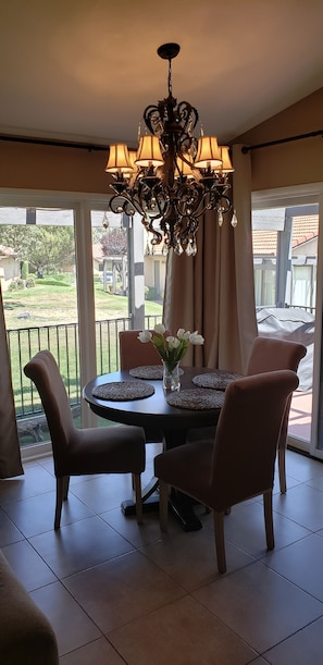 A dining area with a chandelier, a round table, and chairs. - Mountain Home Stallion Springs Ca. Luxury accommodation with Incredible views. (Tehachapi)