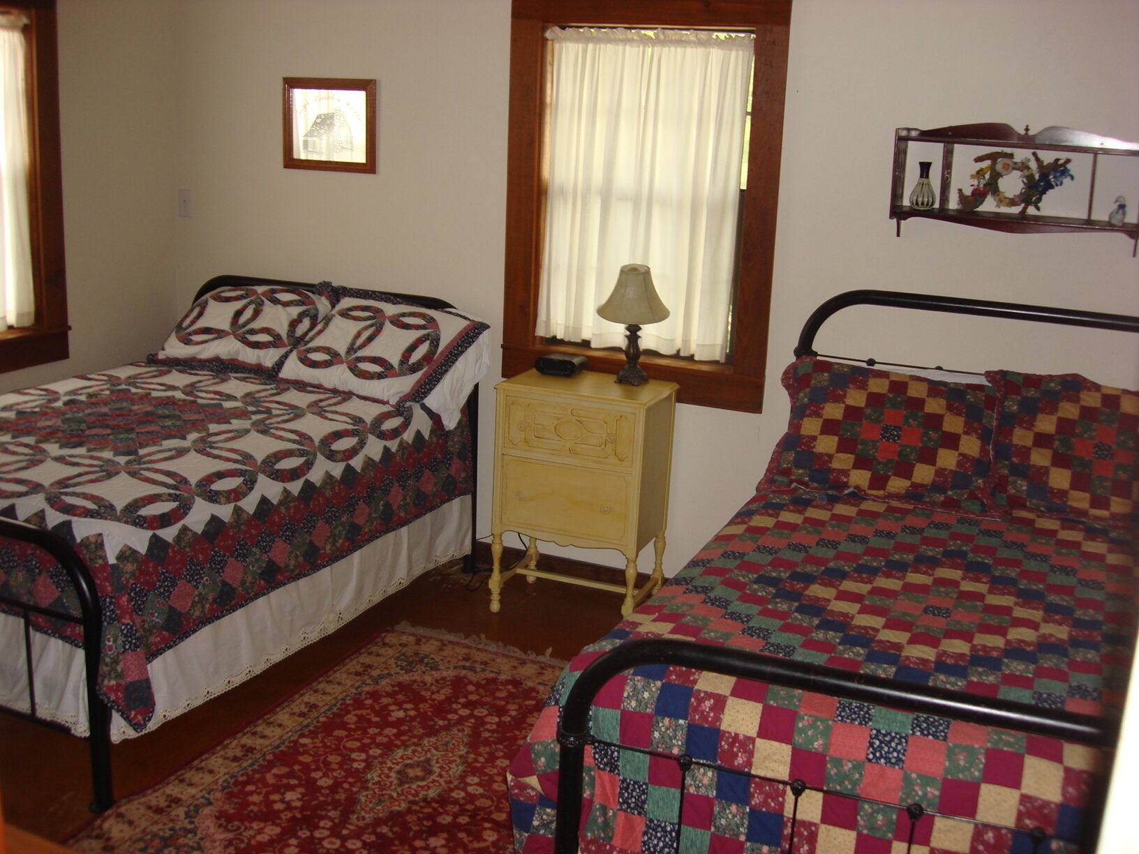 Second bedroom has 2 double beds, a dresser on opposite wall and an ample closet