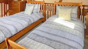 Une chambre à coucher avec deux lits en bois, une table de chevet et une lampe.