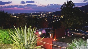 A nighttime cityscape with a distant view of a city, a fence, and some greenery in the foreground. - Villa with private swimming pool, garden & sea view Forte Dei Marmi   (Pietrasanta)