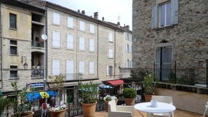 Une terrasse agrémentée de plantes en pot, avec une table et des chaises.
