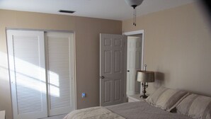 Une chambre à coucher comprenant un lit, une table de chevet, une lampe et une armoire avec des portes coulissantes.