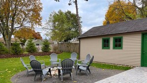 A patio with outdoor seating and a building with a green door. - Remodeled home 1 mile from Notre Dame (1150) (South Bend)