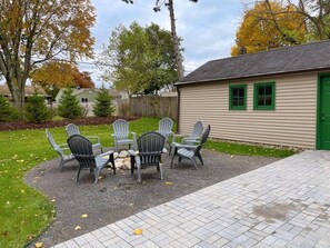 A patio with outdoor seating and a building with a green door. - Remodeled home 1 mile from Notre Dame (1150) (South Bend)